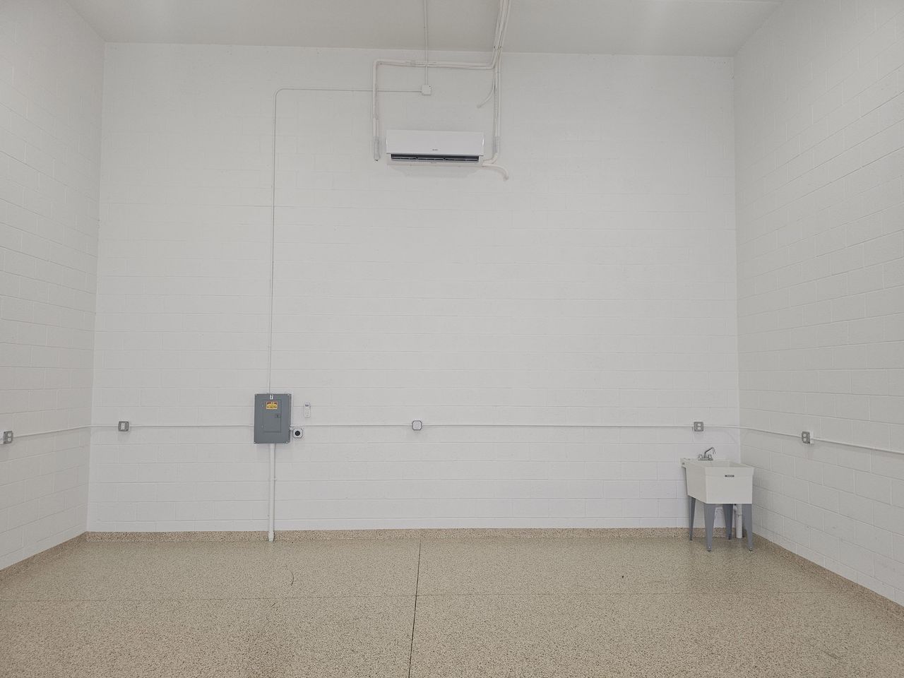 Boat garage interior wall with air conditioning unit, outlets and utility sink